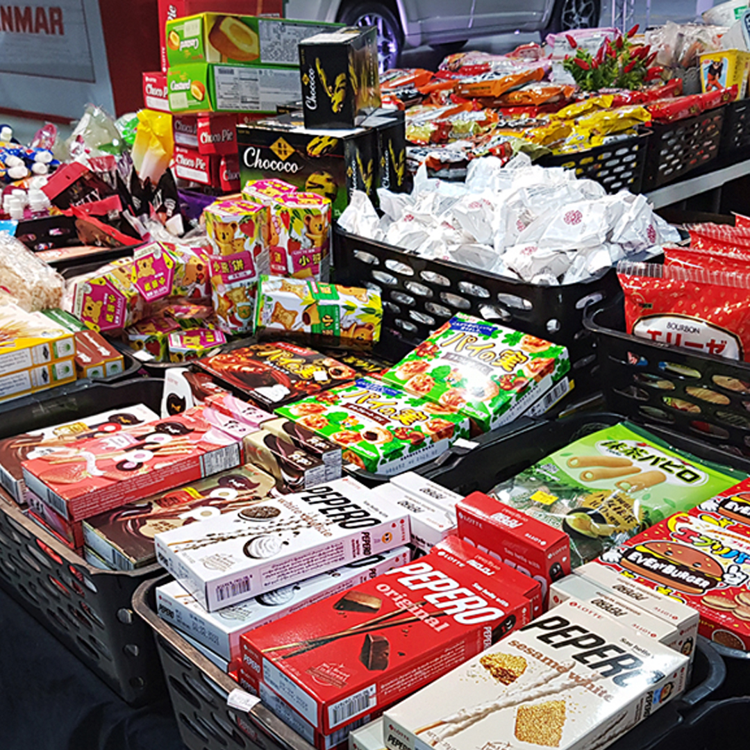 Barraca com cestas cheias de doces e biscoitos japoneses, como caixas de Pepero e Chococo.